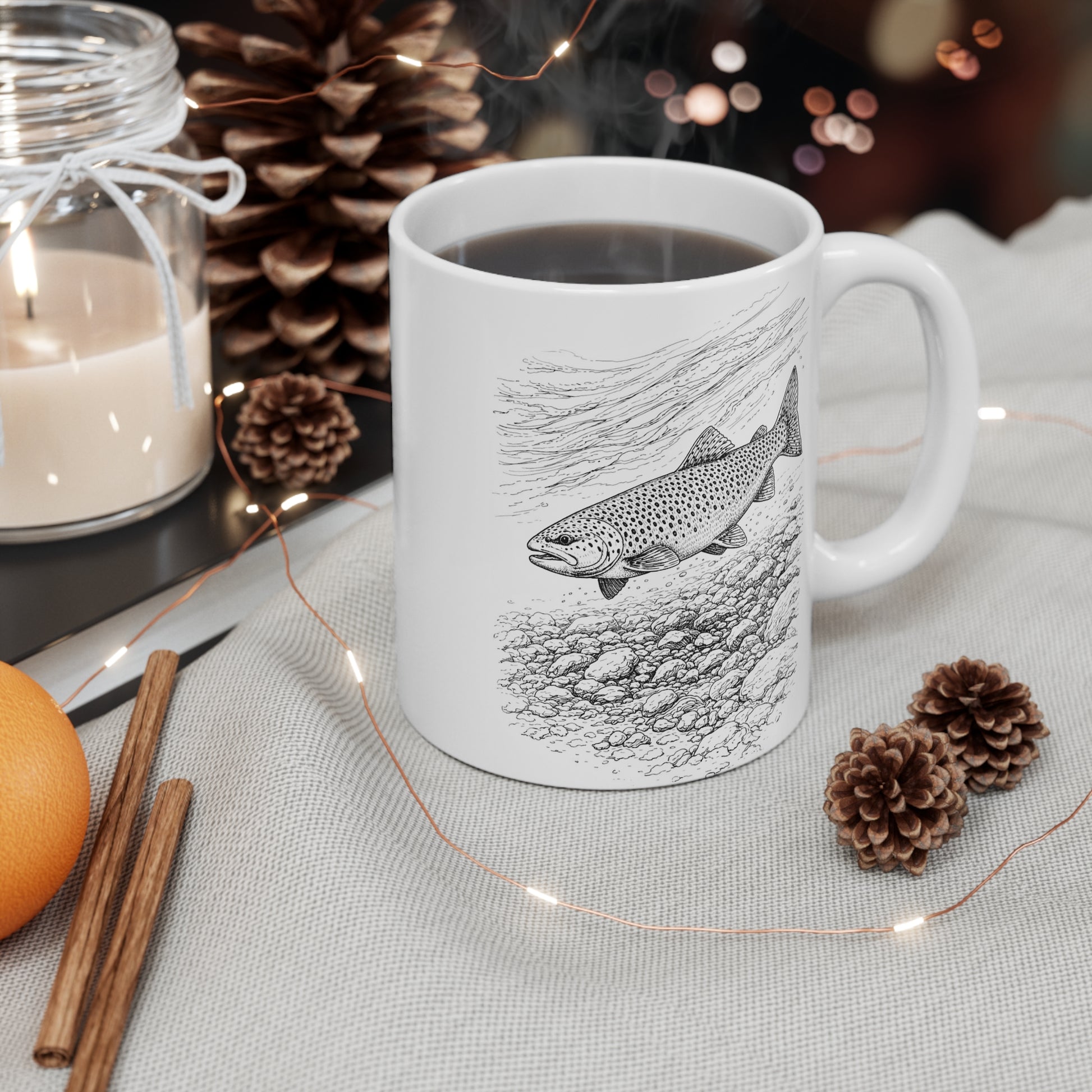 Brown trout illustration mug with festive decor of candles, pinecones, cinnamon sticks and oranges – wildlife fishing gift